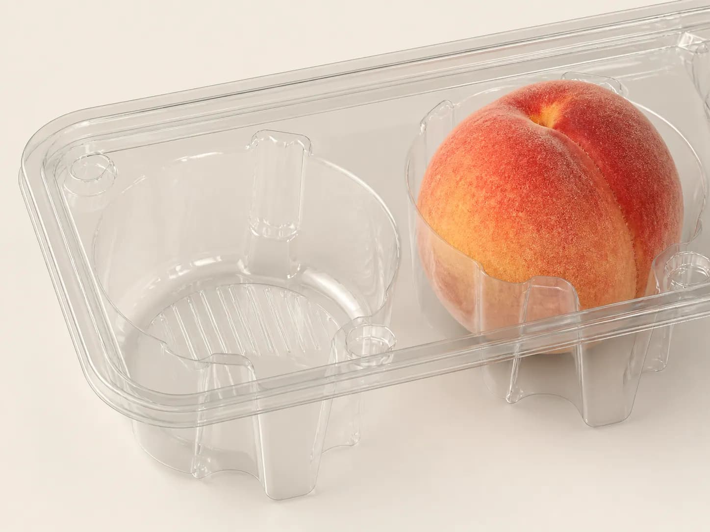 AI packaging illustration: close-up of one clear molded peach support tray corner showing two rounded cavities and structural ribs, one peach seated in its own cavity, realistic clear thin material
