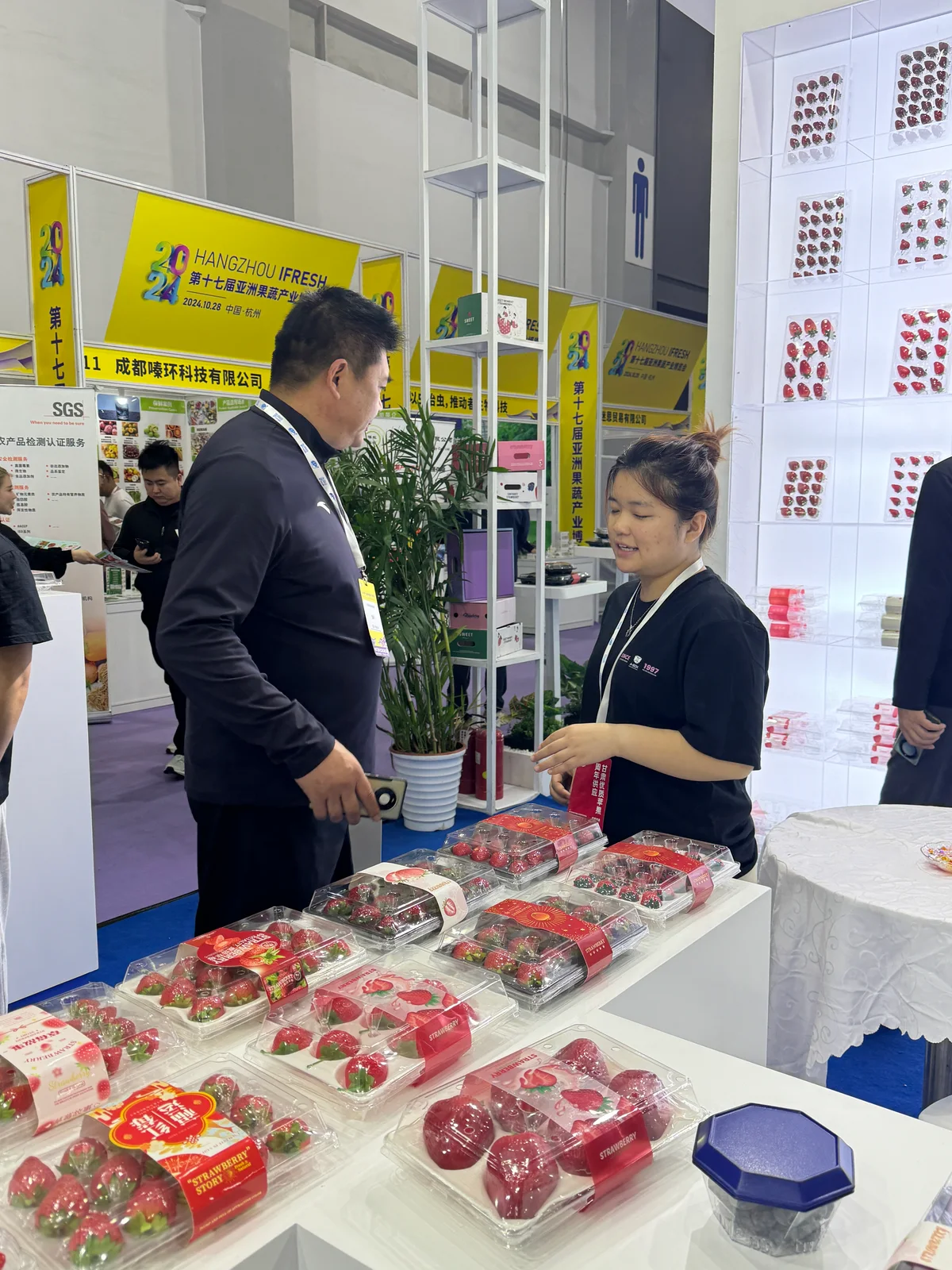 A group discussing fruit boxes at an exhibition