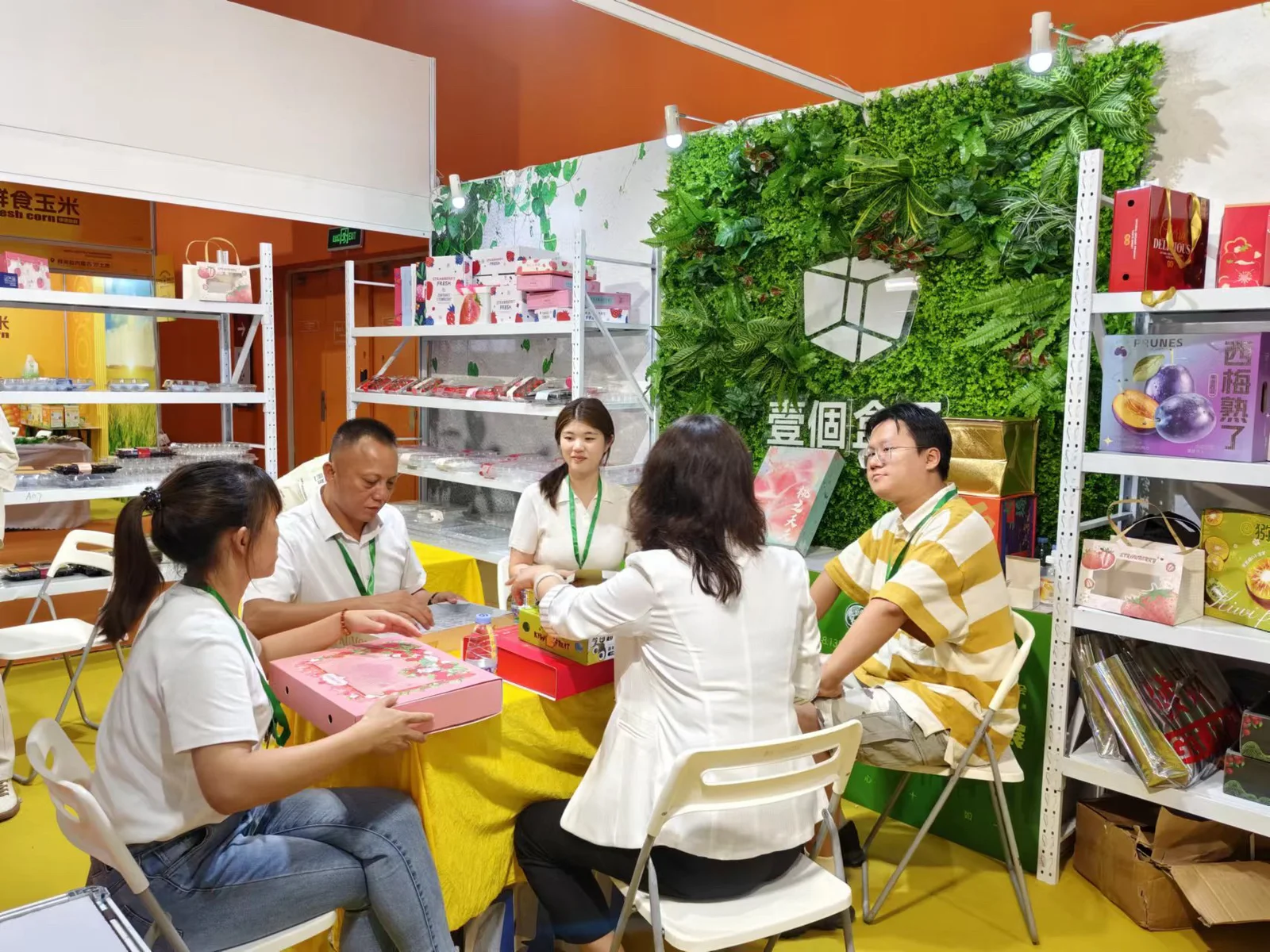 A group meeting around fruit packaging at the A BOX booth