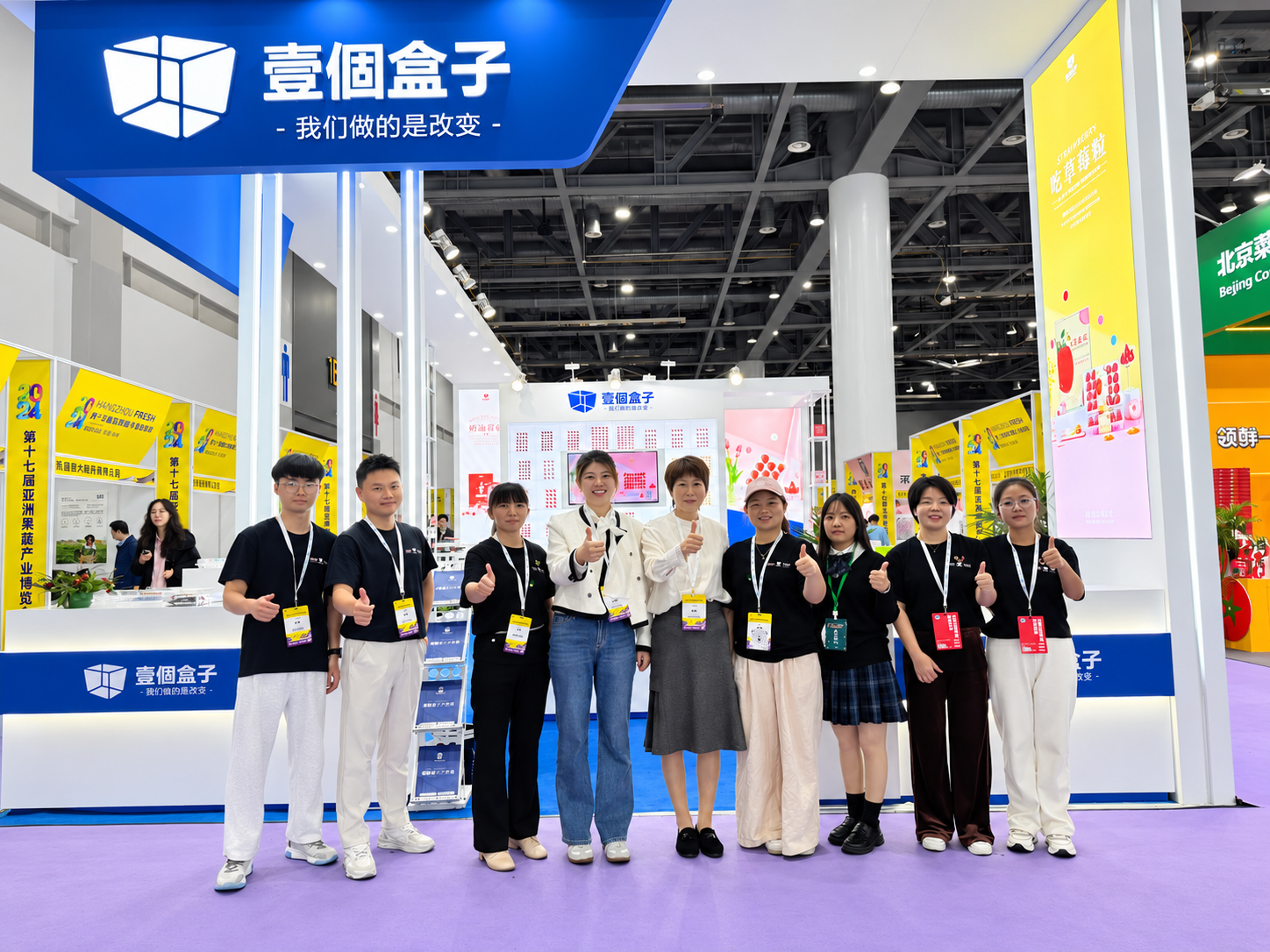 A BOX exhibition team beside packaging displays