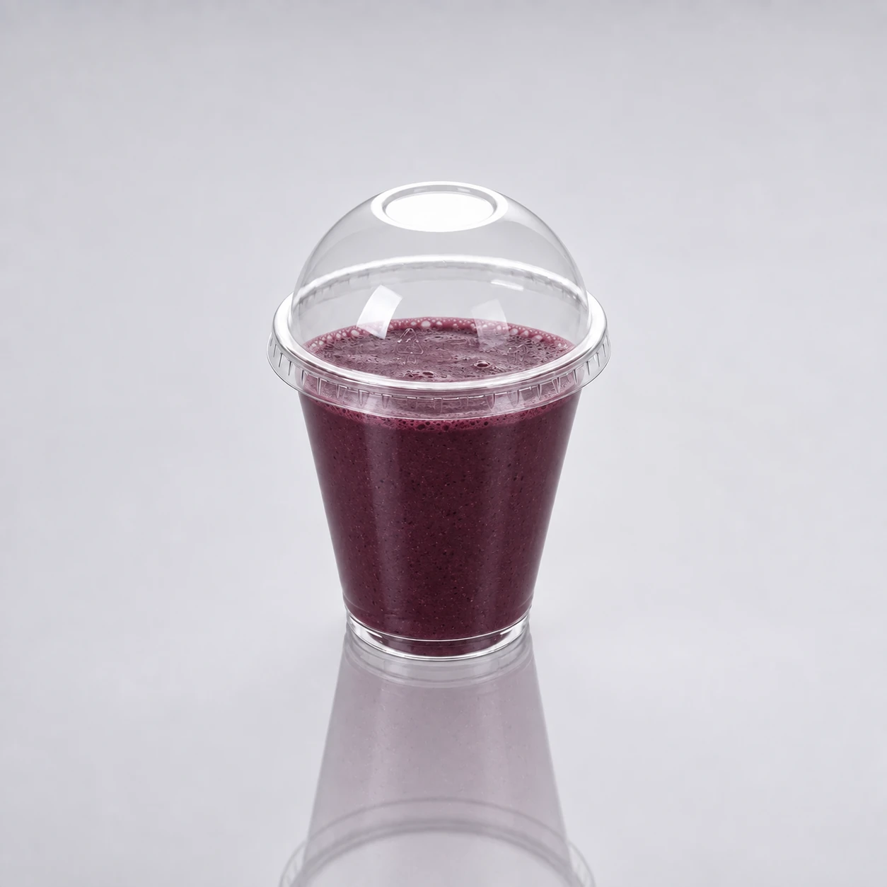 Purple smoothie in tapered clear cup, open dome lid.
