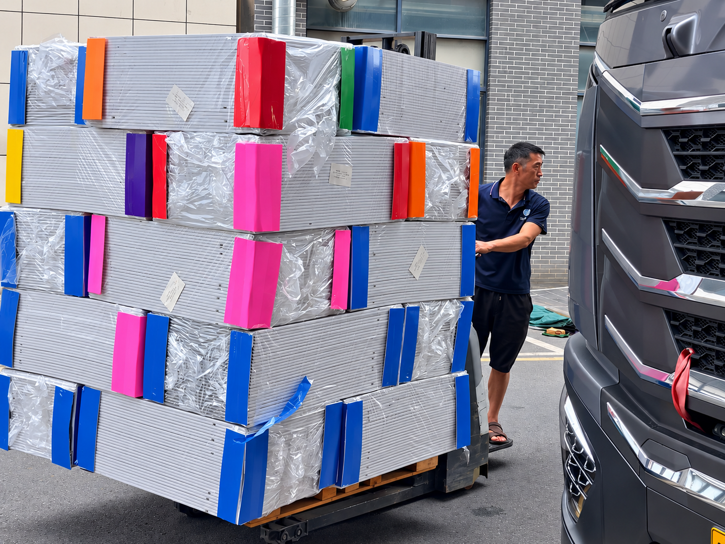 Wrapped stacks on pallets beside a pallet jack
