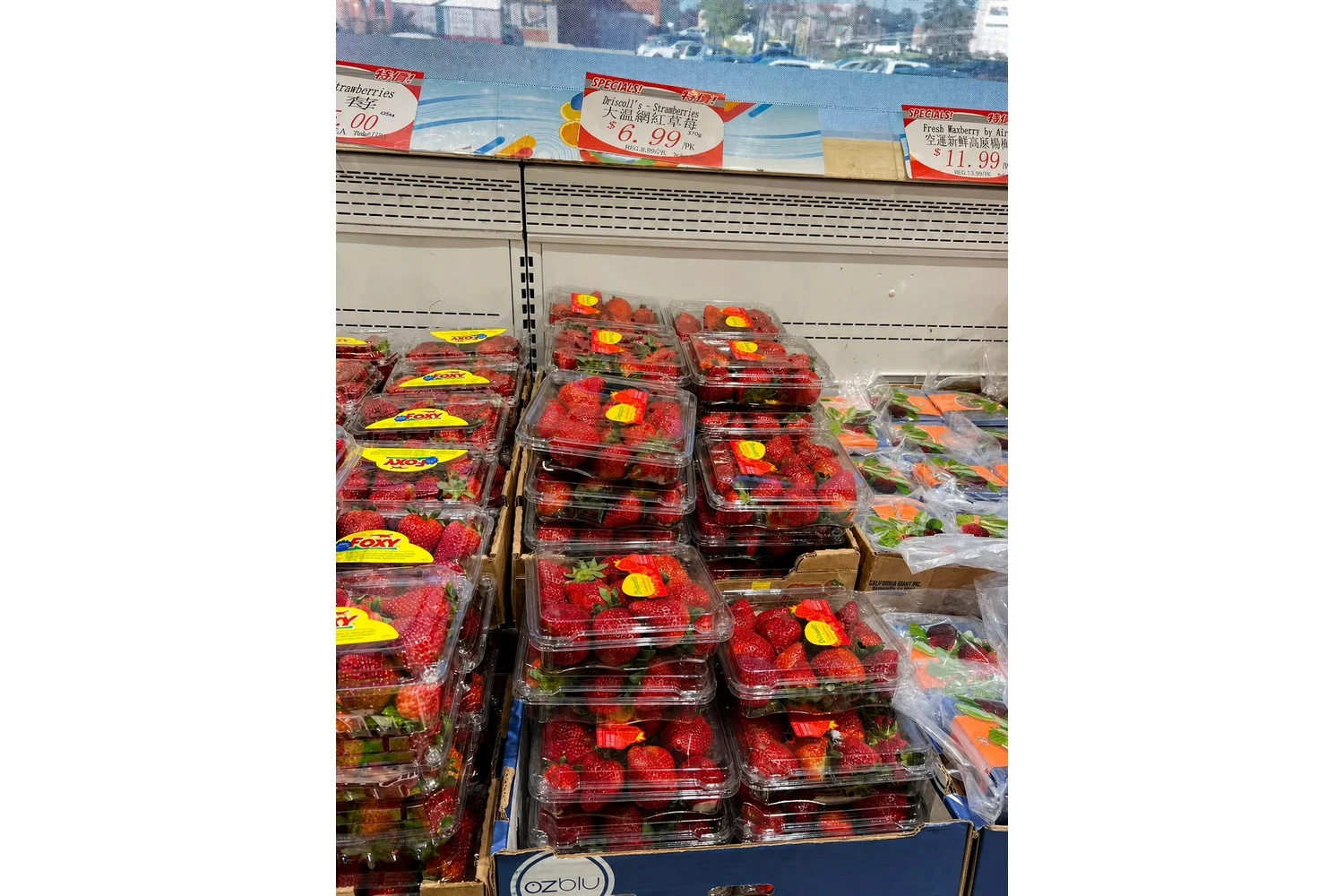 Clear retail packaging keeps strawberries visible while carrying price and brand information.